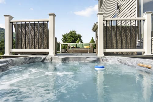 Private hot tub at Malkita Aria villa in Woodbury with mountain views, surrounded by modern white pergolas and outdoor