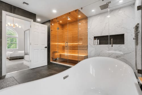 Luxury bathroom at Malkita Aria villa in Woodbury with soaking tub, wooden steam shower, and marble accents.