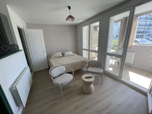 Studio à Guimiliau avec lit, coin salon, parquet, portes vitrées donnant sur balcon avec vue mer