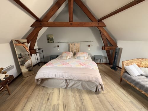 Spacieuse chambre mansardée à la Ferme de la Forterie B&B à Verlinghem avec poutres apparentes, lit queen-size et vue sur jardin