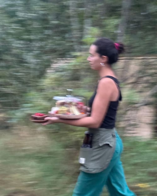 Femme jogging sur un sentier forestier près des Micro Palaces à Vaulx, France, tenant une assiette de nourriture