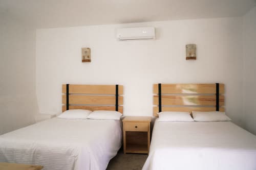 Habitación doble en Hotel El Porvenir con dos camas, cabeceros de madera, aire acondicionado y servicios modernos en Querétaro
