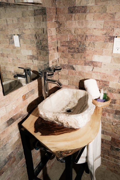 Lavabo rústico de piedra con cuenca natural en Hotel El Porvenir, Querétaro