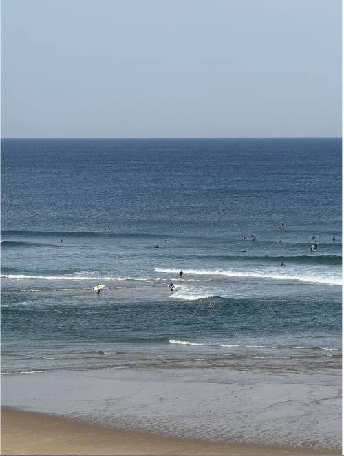 Plage de surf à Nature et Océan B&B à Messanges avec plusieurs surfeurs profitant des vagues