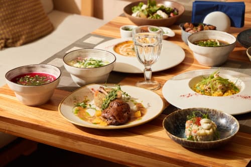 Culinária elegante e refinada no Tomás Barqueiro no Douro, apresentando pratos gourmet com ervas frescas e uma apresentação sofisticada