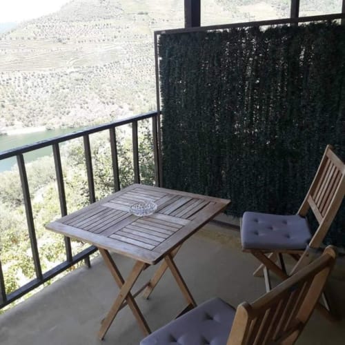Varanda de hospedagem na pousada Tomás Barqueiro B&B no Douro, Portugal com mesa, cadeiras e vista para os vinhedos