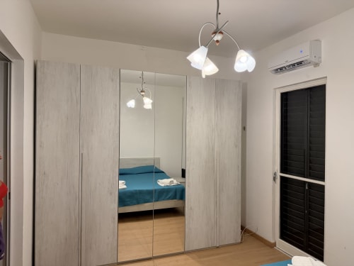 Camera moderna a Zappy Domus a Castellaneta Marina con armadio a specchio, illuminazione a sospensione e biancheria da letto blu