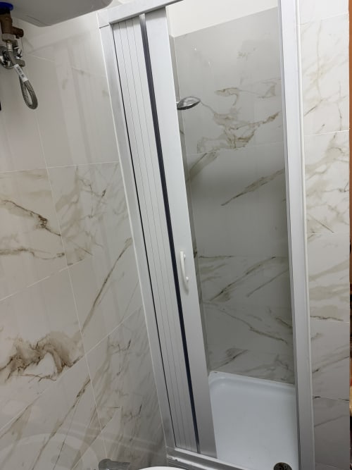 Moderna cabina doccia con piastrelle effetto marmo nell'appartamento Tereskova di Zappy Domus B&B, Castellaneta Marina