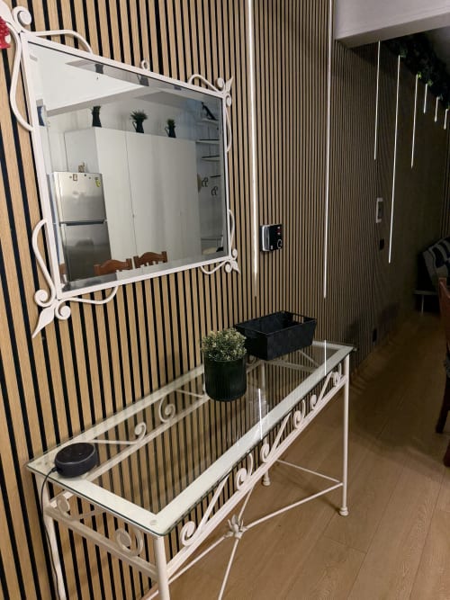 Accogliente entrata dell'appartamento Zappy Domus con specchio bianco, tavolo in vetro e parete a righe a Castellaneta