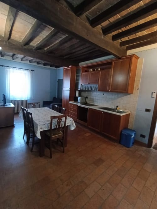 Rustic kitchen-dining area in Appartamento 4 at Agriturismo Aggazzotti, Colombaro, with exposed beams and wooden cabinets