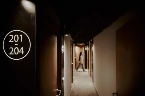 Pasillo del hostal Zarey con señalización de habitaciones 201-204 en Perillo, España