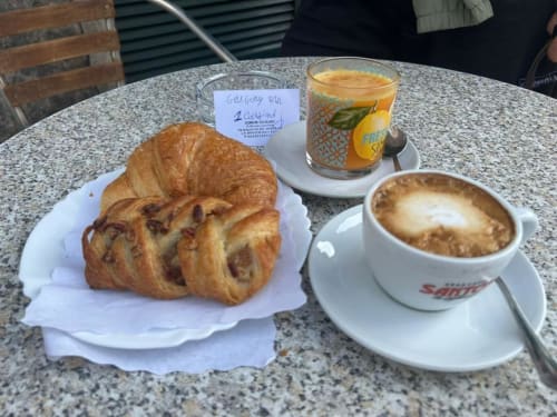 Colazione a Domum Vaticani Roma: cornetto, pasticcino, cappuccino e succo d'arancia su tavolo all'aperto