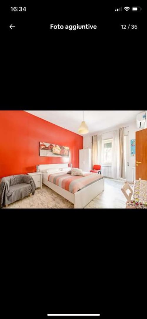 Camera da letto doppia moderna presso Domum Vaticani Rome B&B con parete accent rossa, letto bianco e biancheria a righe