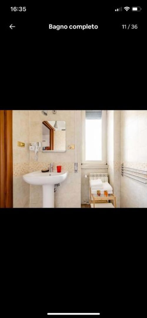 Bagno completo in Domum Vaticani B&B a Roma con lavabo colonna, specchio, portasciugamani e finestra