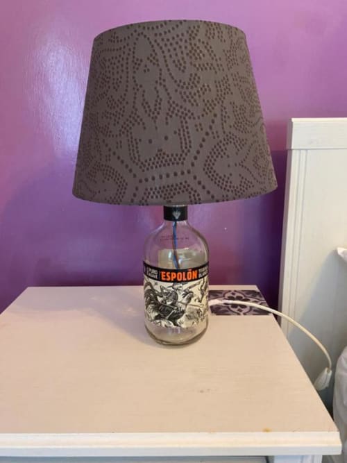 Lampada decorativa con base in bottiglia Espolòn e paralume traforato in camera d'albergo a Roma
