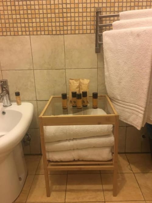 Bagno con asciugamani, ripiano con amenities e lavabo presso il bed and breakfast Domum Vaticani a Roma