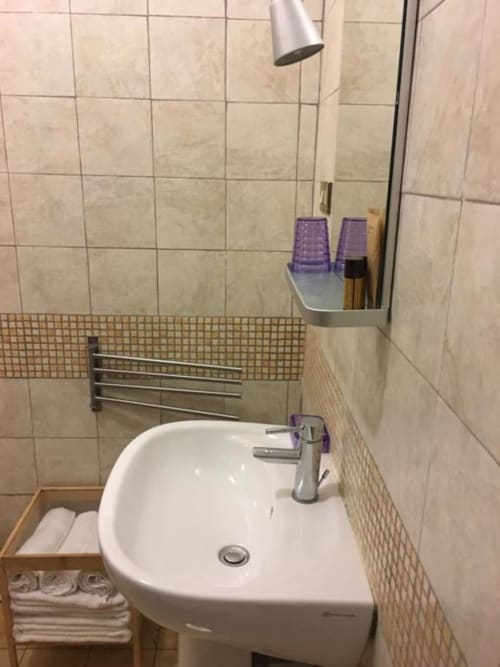 Moderno lavabo del bagno con rubinetto, portasciugamani e ripiano contenitore presso il B&B Domum Vaticani a Roma