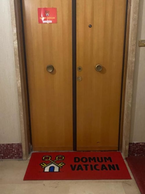 Porte ascensore in legno presso il Domum Vaticani B&B a Roma con zerbino rosso con logo delle chiavi vaticane