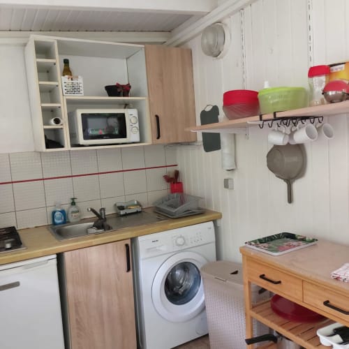 Kitchenette compacte du Bungalow Célyote aux Saintes avec micro-ondes, lave-linge, évier et rangements ouverts