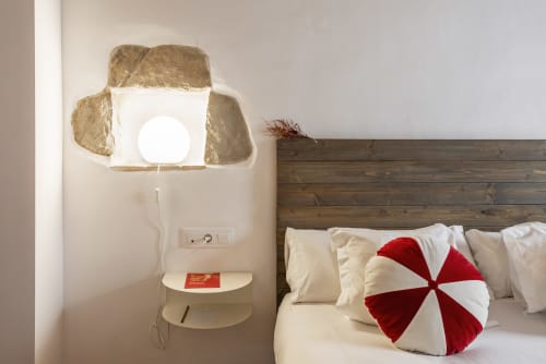 Acogedora habitación en Casa Merceditas con cabecero de madera, almohada decorativa roja y blanca, y pared única estilo cartón de huevos