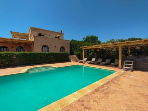 Villa Castellum B&B avec piscine turquoise, terrasse en terre cuite, pergola en bois et villa en pierre en France