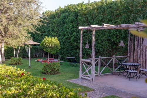 Jardin de Villa Castellum avec pergola en bois, coin détente, haie lierre et pelouse soignée à la française