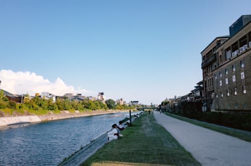 Passeio à beira do rio no Porto com edifícios históricos, margens verdes e águas tranquilas