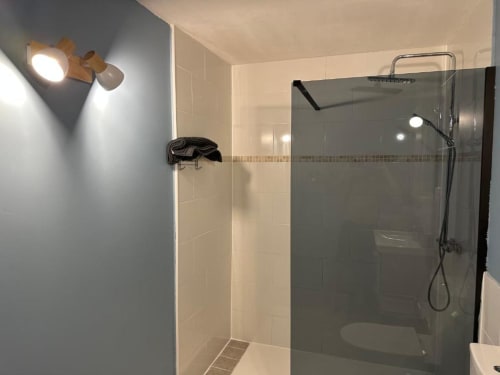 Salle de bain moderne avec douche à l'italienne et paroi vitrée à l'appartement Caress'antillaise à Deshaies, Guadeloupe