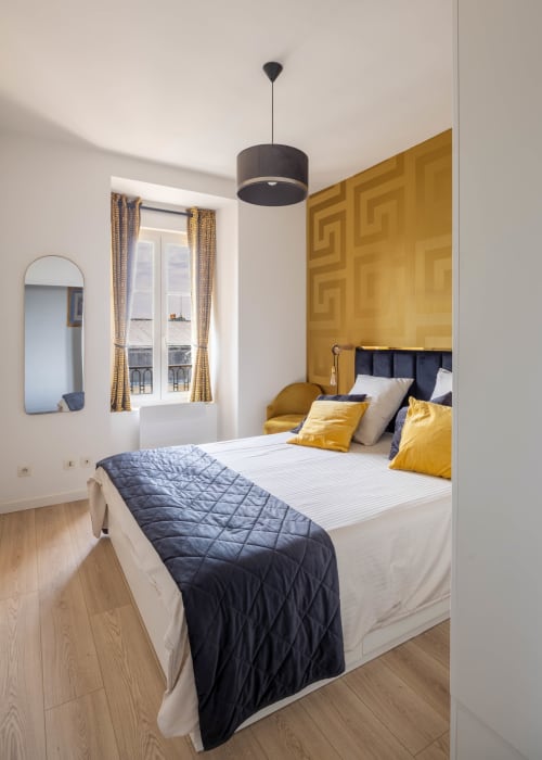 Chambre élégante de l'appartement La Bulle Dorée aux Secrets de Chef de Cave, Épernay, avec mur accent doré et suspension moderne