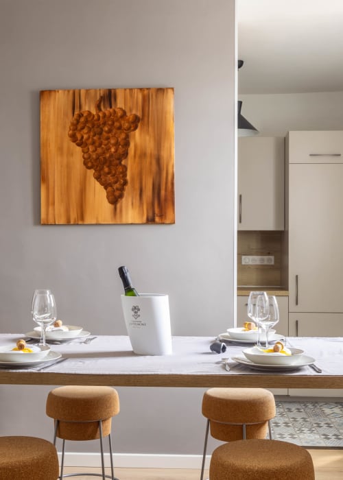 Élégant aménagement gastronomique aux Secrets de Chef de Cave avec décor de raisins en bois, mise de table et seau à vin à Épernay