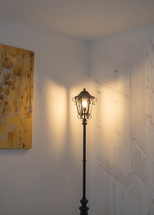 Lampadaire vintage illuminant les murs blancs dans l'appartement La Bulle Dorée aux Secrets de Chef de Cave, Épernay