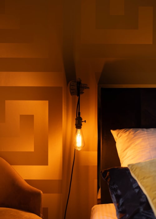 Éclairage ambiant chaleureux dans l'appartement La Bulle Dorée aux Secrets de Chef de Cave, Épernay, avec suspension luminaire industrielle