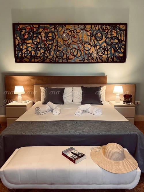 Lussuosa camera da letto nella Villa degli Angeli a Puglia con arte moderna, biancheria bianca, cuscini scuri e calorosa ospitalità