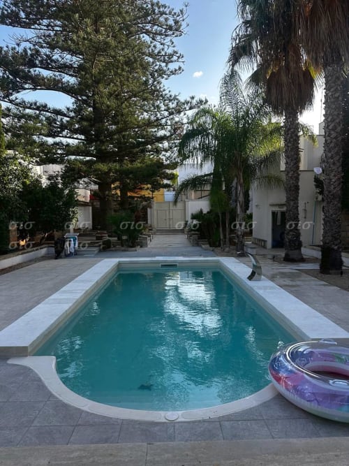 Piscina turchese con lettini bianchi a Villa degli Angeli, tenuta di Nardò in Puglia