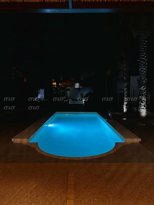 Piscina illuminata di blu nella notte della corte Villa degli Angeli, Tenuta Puglia, Nardò