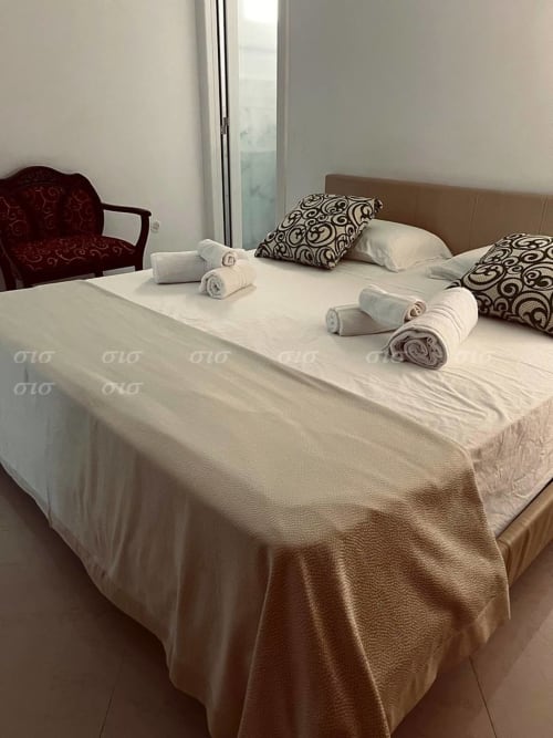 Camera da letto di Villa degli Angeli a Nardò con asciugamani arrotolati, cuscini decorativi e vista sulla piscina