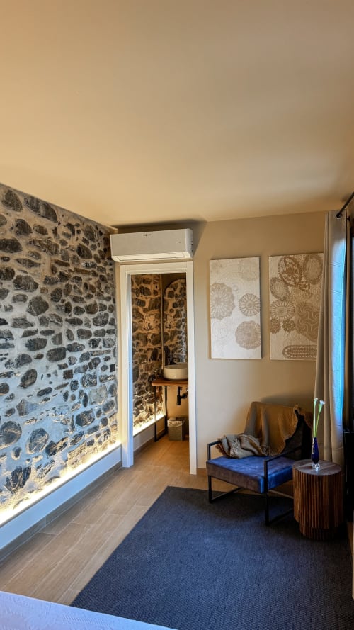 Camera moderna presso Talking Stones B&B a Dolceacqua con muri in pietra a vista, arredi contemporanei e aria condizionata