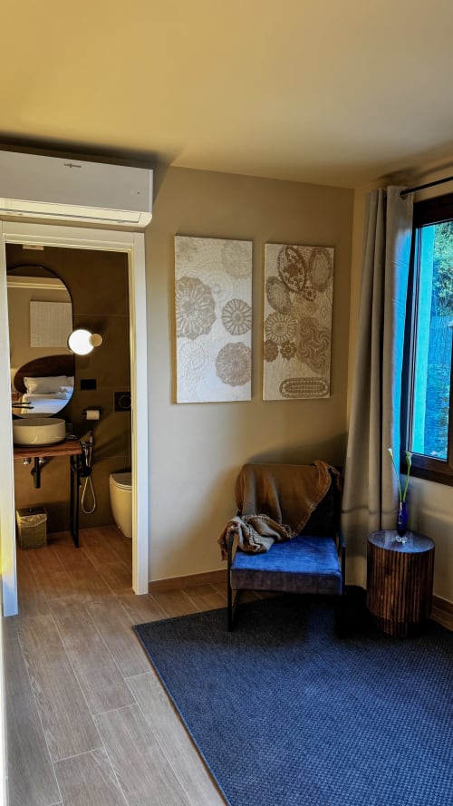 Camera NERVIA N°23 del Talking Stones B&B a Dolceacqua con ingresso camera, poltrona, arte murale e bagno privato
