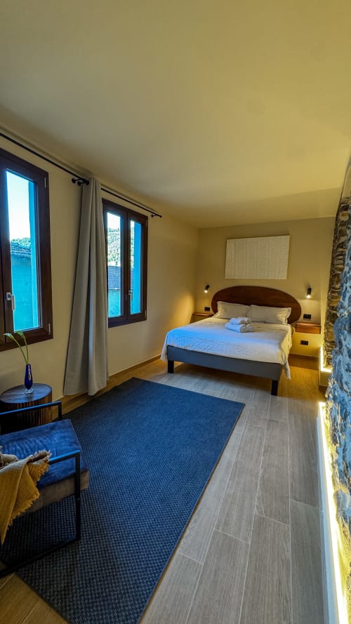 Camera moderna al Talking Stones B&B di Dolceacqua - Nervia Room 23 con letto queen, pareti gialle e accenti blu