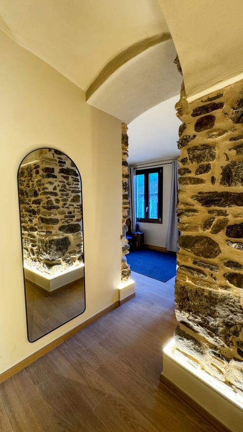 Corridoio moderno con muri in pietra a vista e soffitto a volta presso il Talking Stones BnB a Dolceacqua, Italia