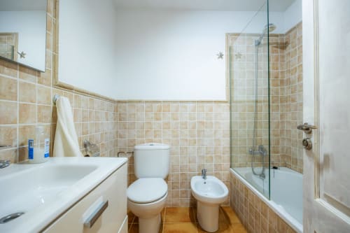 Baño moderno en Apartamento Jaume B, Artà con azulejos beige, lavabo, inodoro, bidé y ducha con mampara de cristal