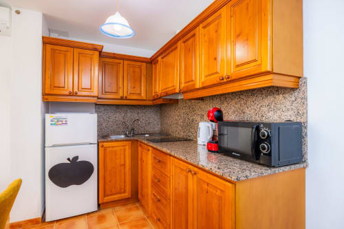 Cocina moderna en Apartamento Jaume B, Artà con muebles de madera, encimera de granito y electrodomésticos de acero inoxidable