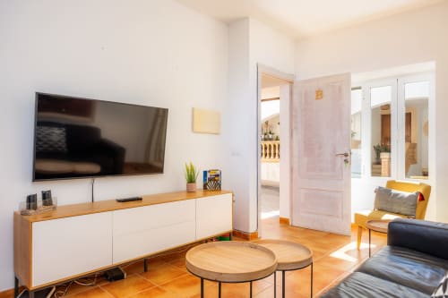 Sala de estar moderna en Apartamento Jaume B, Artà con televisor de pantalla plana, muebles de madera e iluminación natural abundante