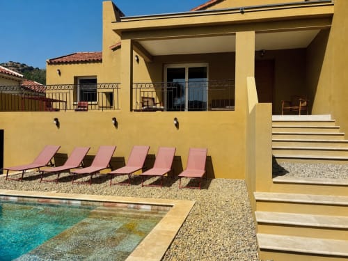 Villa jaune avec piscine, chaises longues et vue sur les montagnes en Balagne