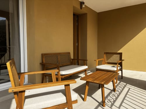 Mobilier de patio en bois avec coussins blancs sur la terrasse ensoleillée de la villa Casa Loc Conciergerie à Calenzana, France