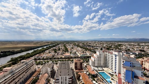 Vista aérea de Empuriabrava con río, montañas y paisaje urbano desde el balcón del apartamento Holidays Costa Brava