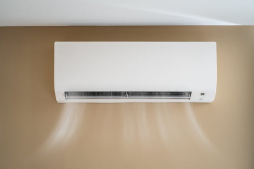Unidade de ar condicionado branco montada em parede bege no hotel boutique AgapeStay Porto