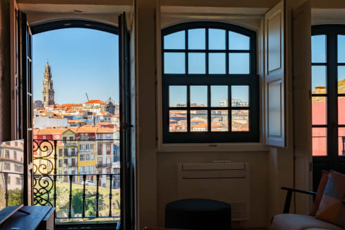 Vista da paisagem urbana do Porto do quarto da AgapeStay Porto com portas de varanda abertas para a arquitetura histórica