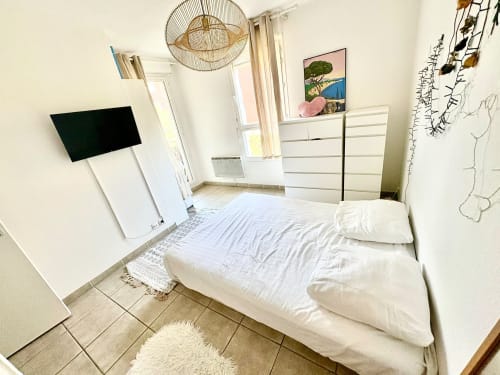 Quarto moderno e brilhante em uma pousada em Aix-en-Provence com cama branca, TV, pisos de madeira e decoração com vista para a cidade
