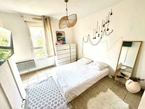Chambre lumineuse au Mas Des Cigales De Lambesc, Aix-en-Provence, avec lit blanc, lampe suspendue tressée et vue sur la ville